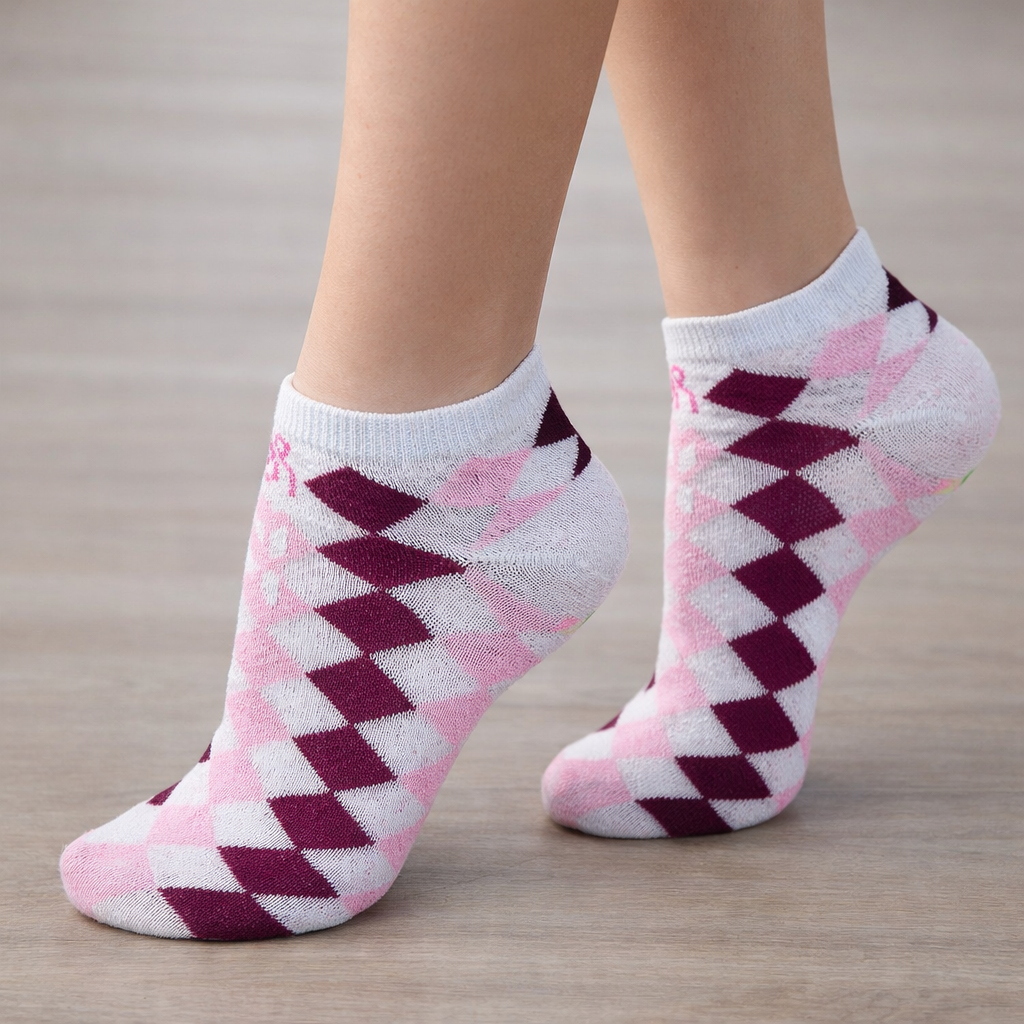 White Ankle socks with pink and purple diamond pattern worn on a wooden floor