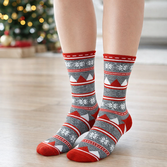 Person wearing festive patterned Crew socks with a blurred Christmas tree in the background