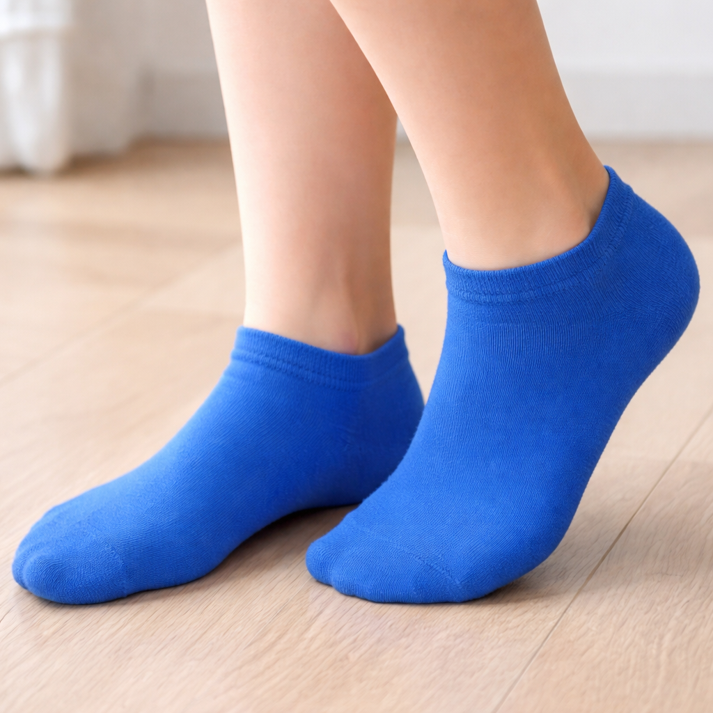 Blue ankle socks worn on a light wooden floor