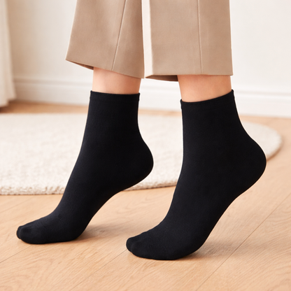 Person wearing black socks on a wooden floor