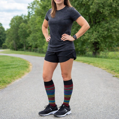 Person wearing black athletic outfit with colorful Dr. Motion Compression knee-high socks 