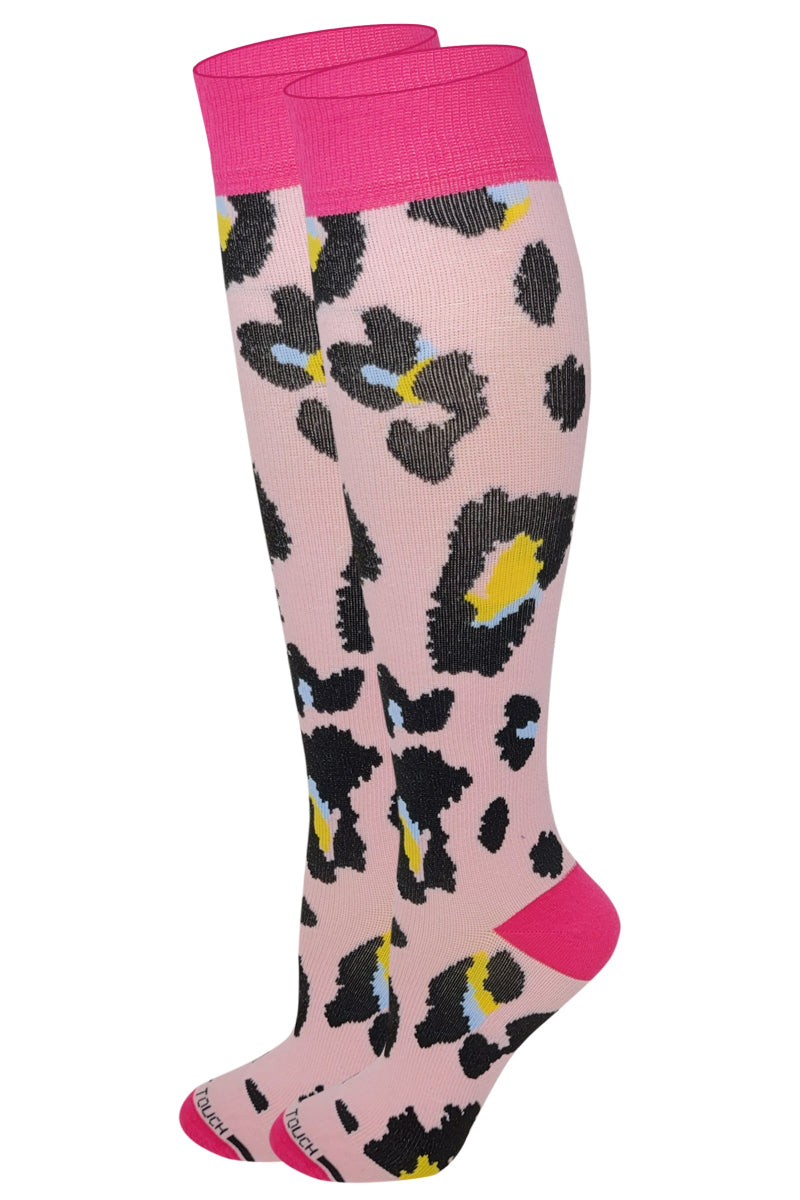 A pair of dr. motion knee-high compression socks with an animal print design in pink, black, and other colors.