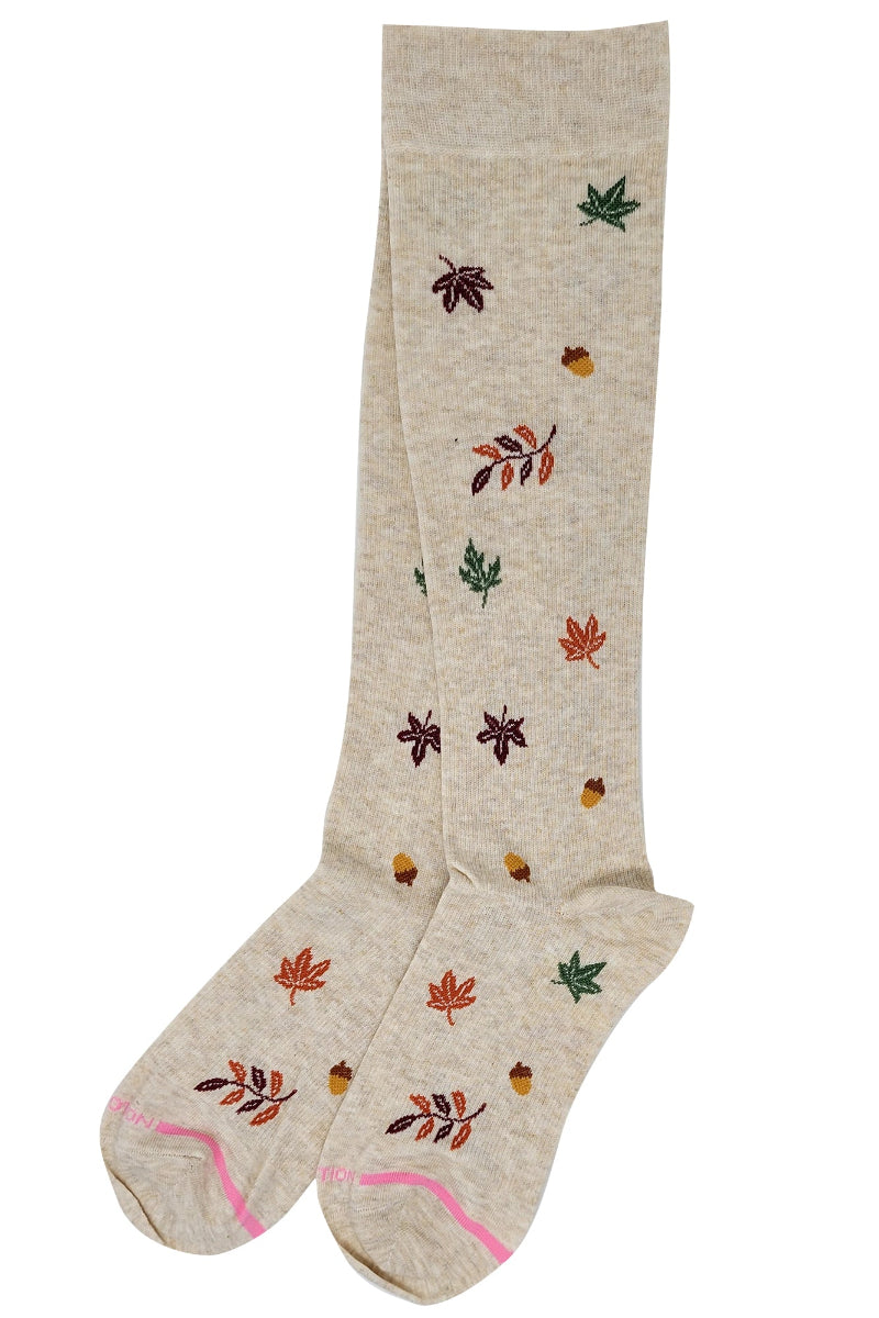 Beige knee-high socks with autumn leaf and acorn pattern on a white background