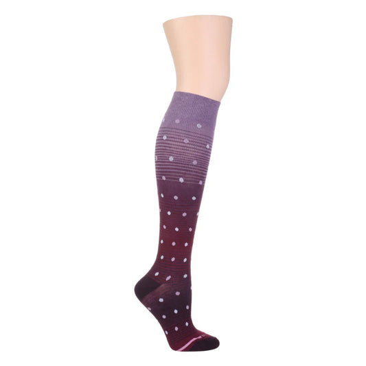 A pair of women's knee high compression socks with dots on an ombre gradient background.