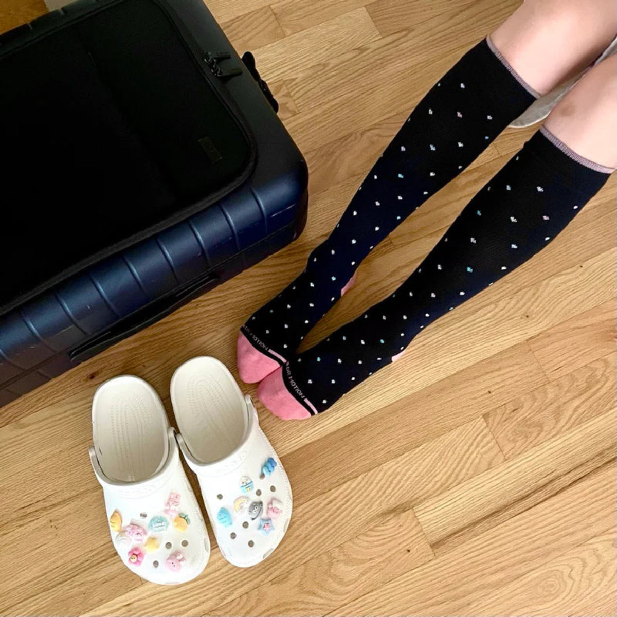 Woman wearing Dr. Motion knee high compression socks with heart pattern for leg support, travel, work, and daily comfort”